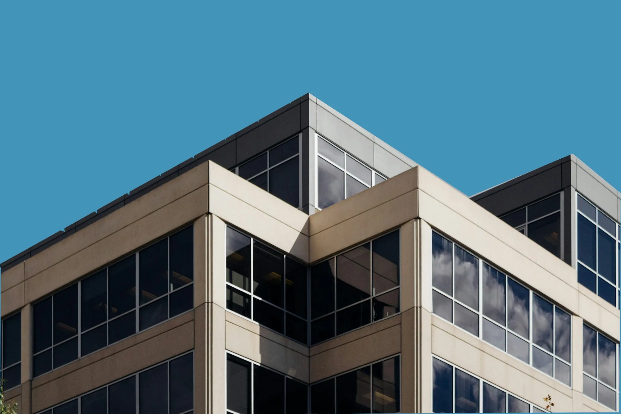 Mid-rise office building with tan panels and dark windows
