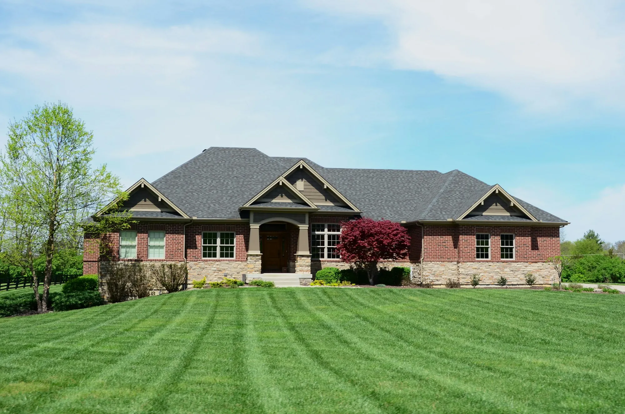 Brick ranch house with a freshly striped front lawn