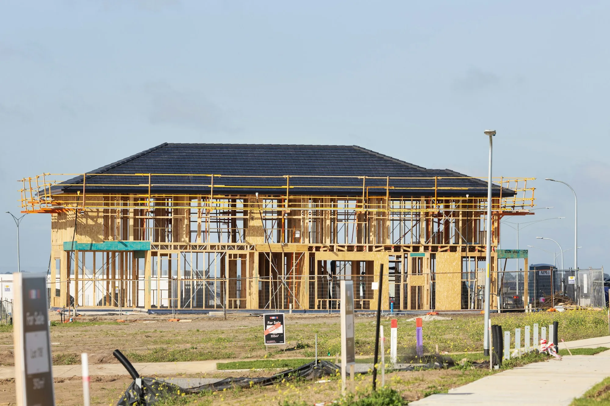 New two-story home with framing and roof under construction